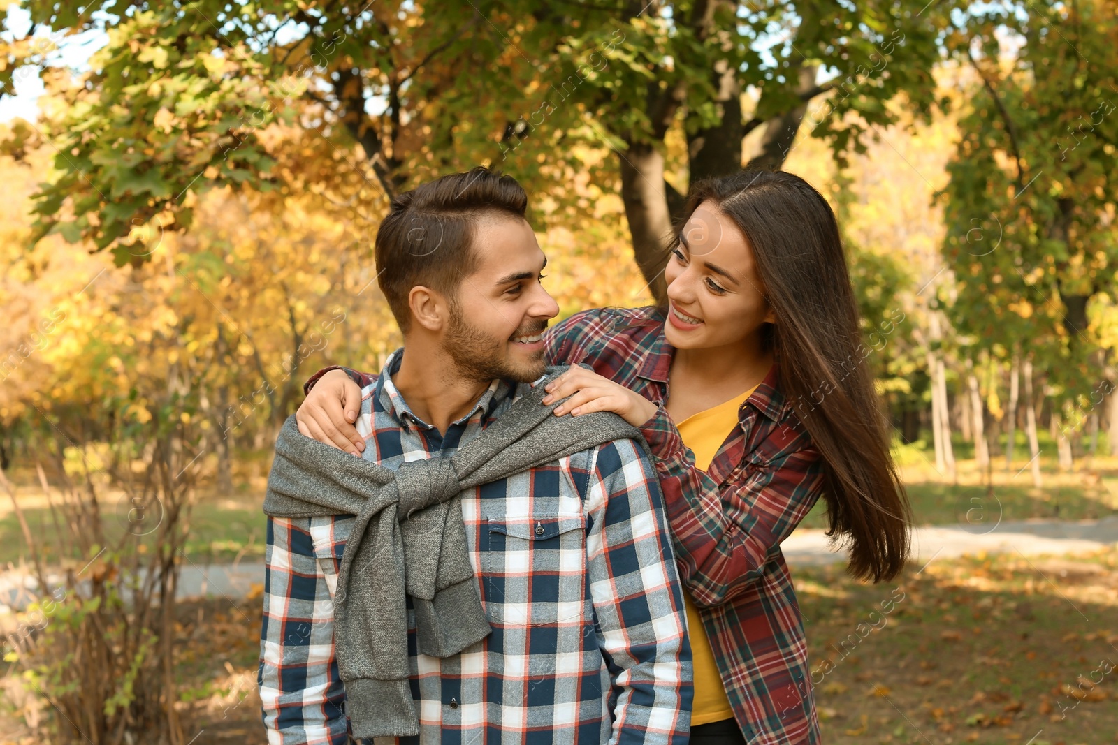 Photo of Young lovely couple spending time together in park. Autumn walk