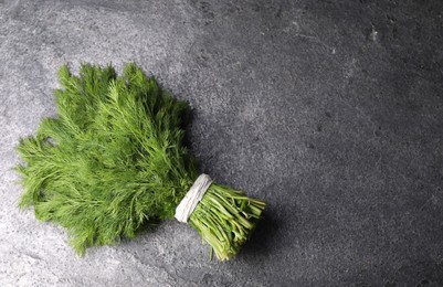 Photo of Bunch of fresh green dill on grey table, top view. Space for text