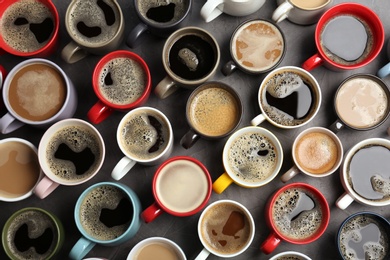 Photo of Many cups with tasty aromatic coffee on table, flat lay