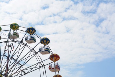 Beautiful observation wheel against blue sky, space for text