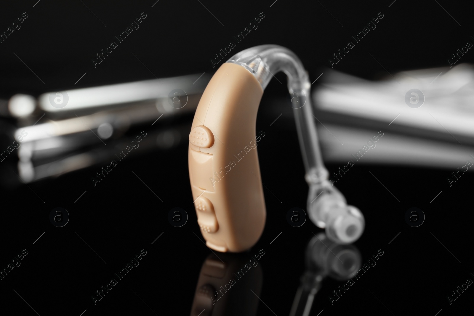 Photo of Hearing aid on black table. Medical device