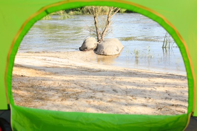 Photo of Calm river with large stones, view from camping tent