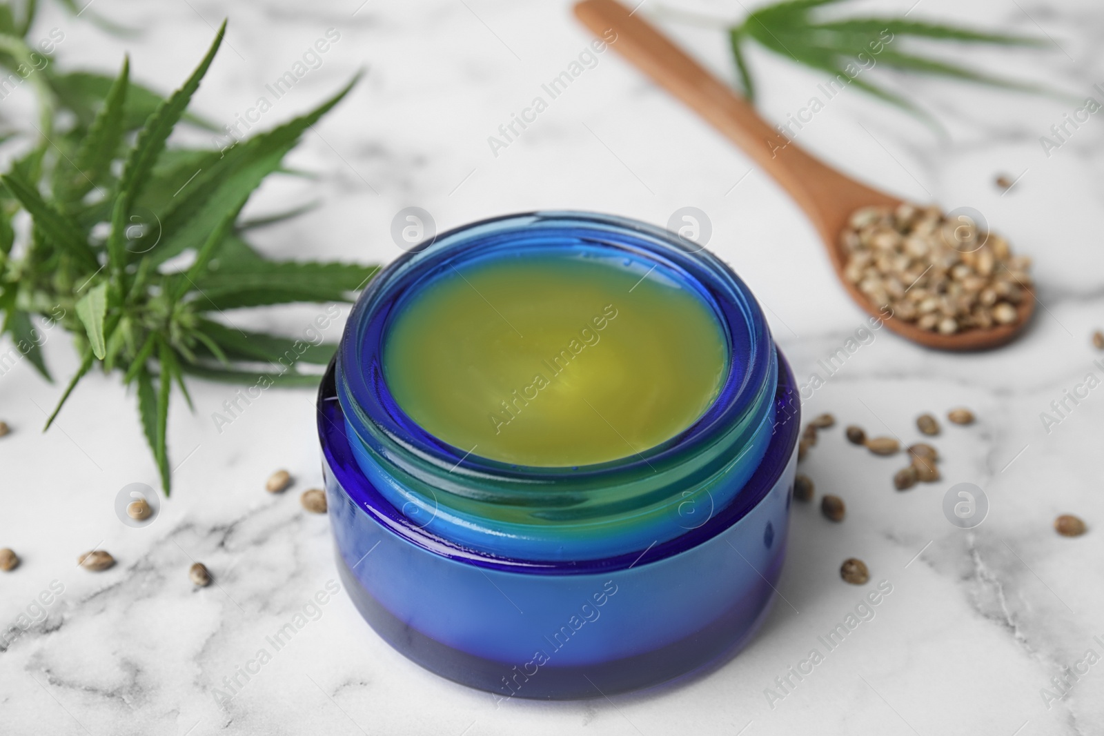 Photo of Jar of hemp cream on marble table, closeup. Organic cosmetics