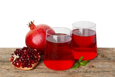 Photo of Refreshing pomegranate juice in glasses, leaves and fruits on wooden table against white background