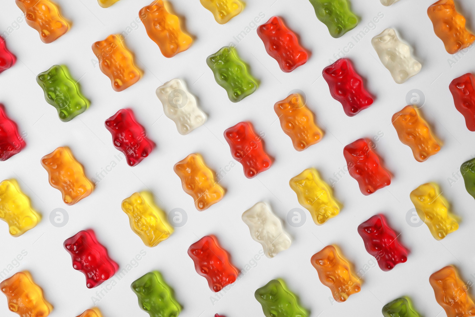 Photo of Delicious color jelly bears on white background, top view