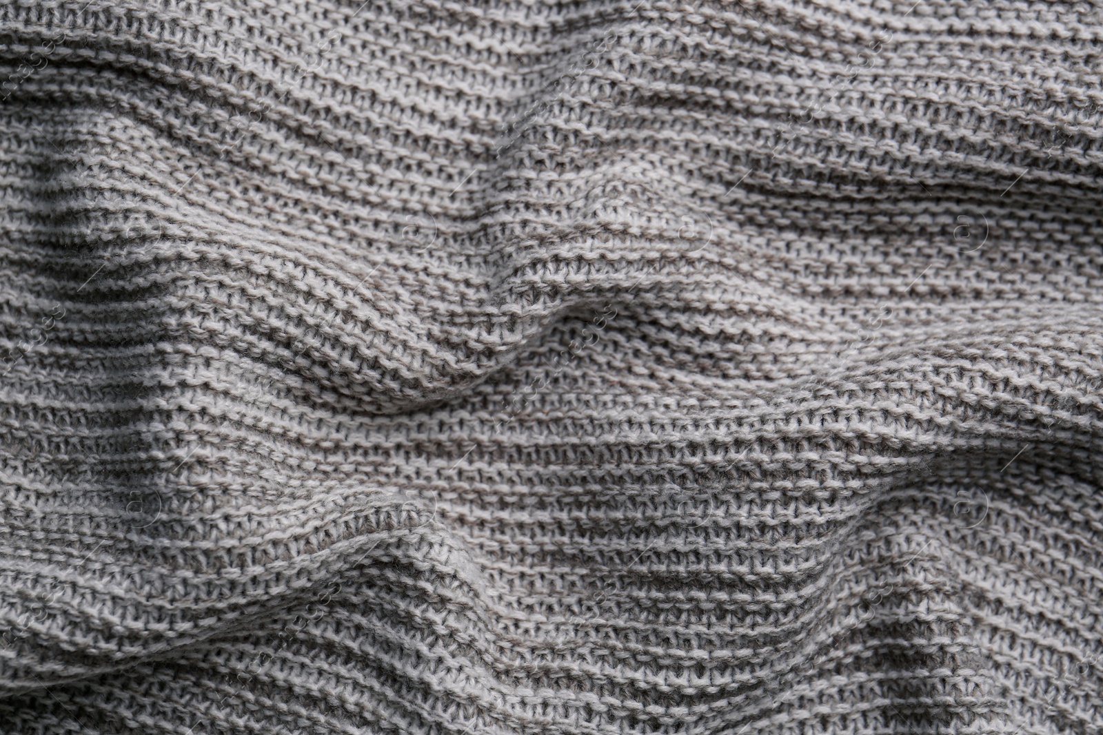 Photo of Beautiful grey knitted fabric as background, top view