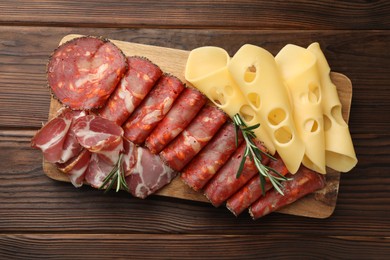 Charcuterie board. Delicious cured ham, cheese, sausage and rosemary on wooden table, top view