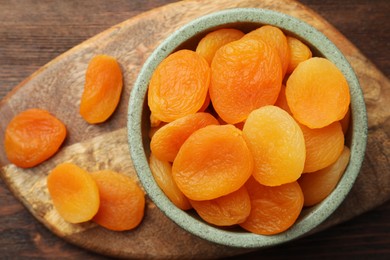 Bowl of tasty apricots on wooden table, top view. Dried fruits