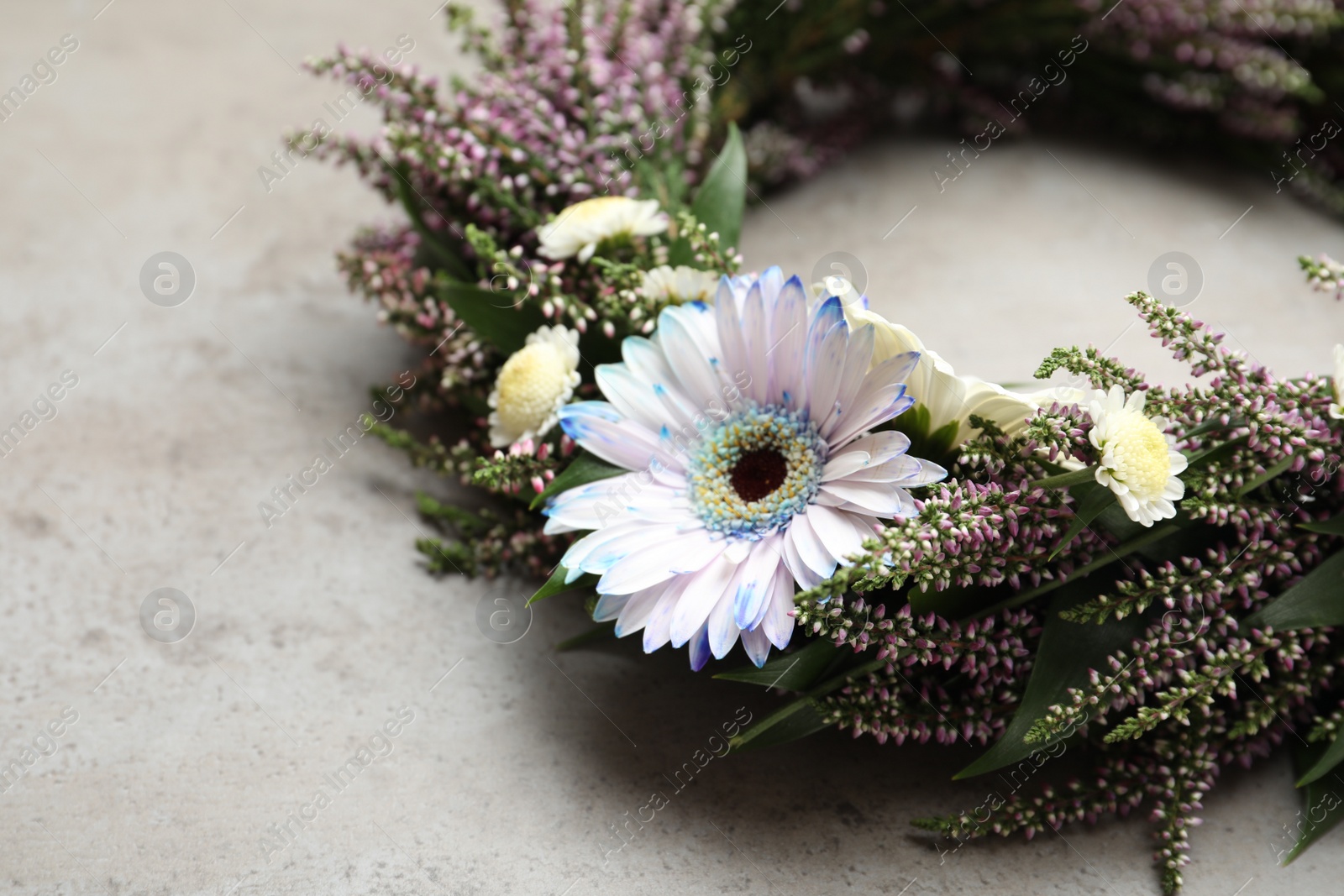 Photo of Beautiful autumnal wreath with heather flowers on light grey background, closeup