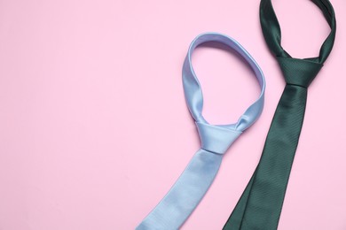Photo of Neckties on pink background, above view. Space for text