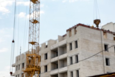 Photo of Blurred view of unfinished building and construction crane outdoors