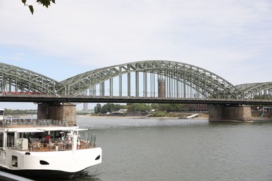 Cologne, Germany - August 28, 2022: Picturesque view of a modern bridge over river and ferry boat