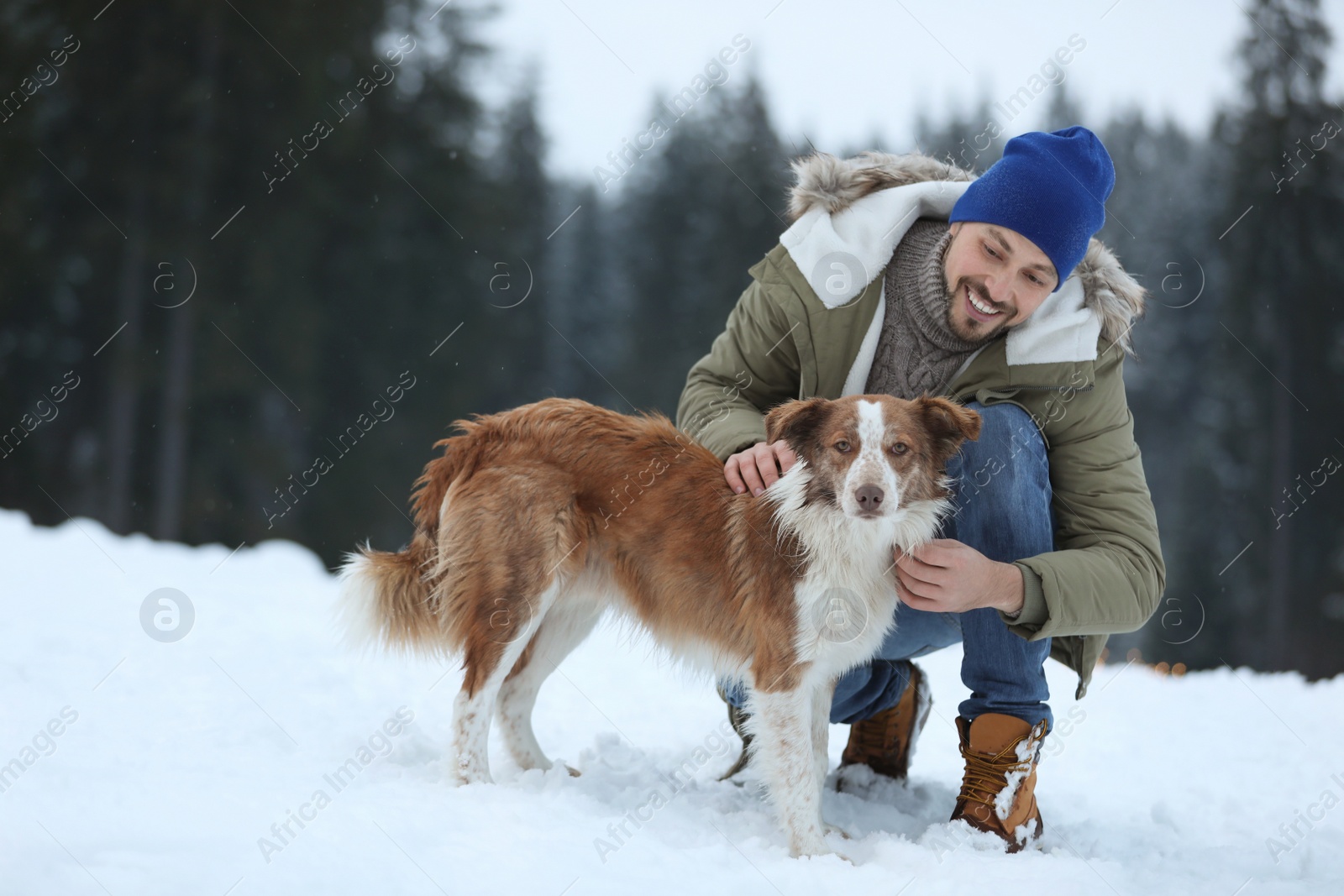 Photo of Man with cute dog near forest. Winter vacation
