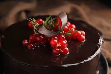 Photo of Tasty homemade chocolate cake with berries and rosemary, closeup