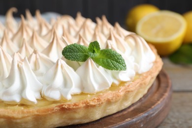 Photo of Delicious lemon meringue pie decorated with mint on table, closeup