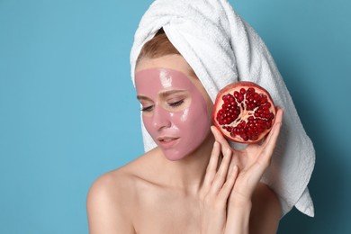 Photo of Young woman with pomegranate face mask and fresh fruit on light blue background