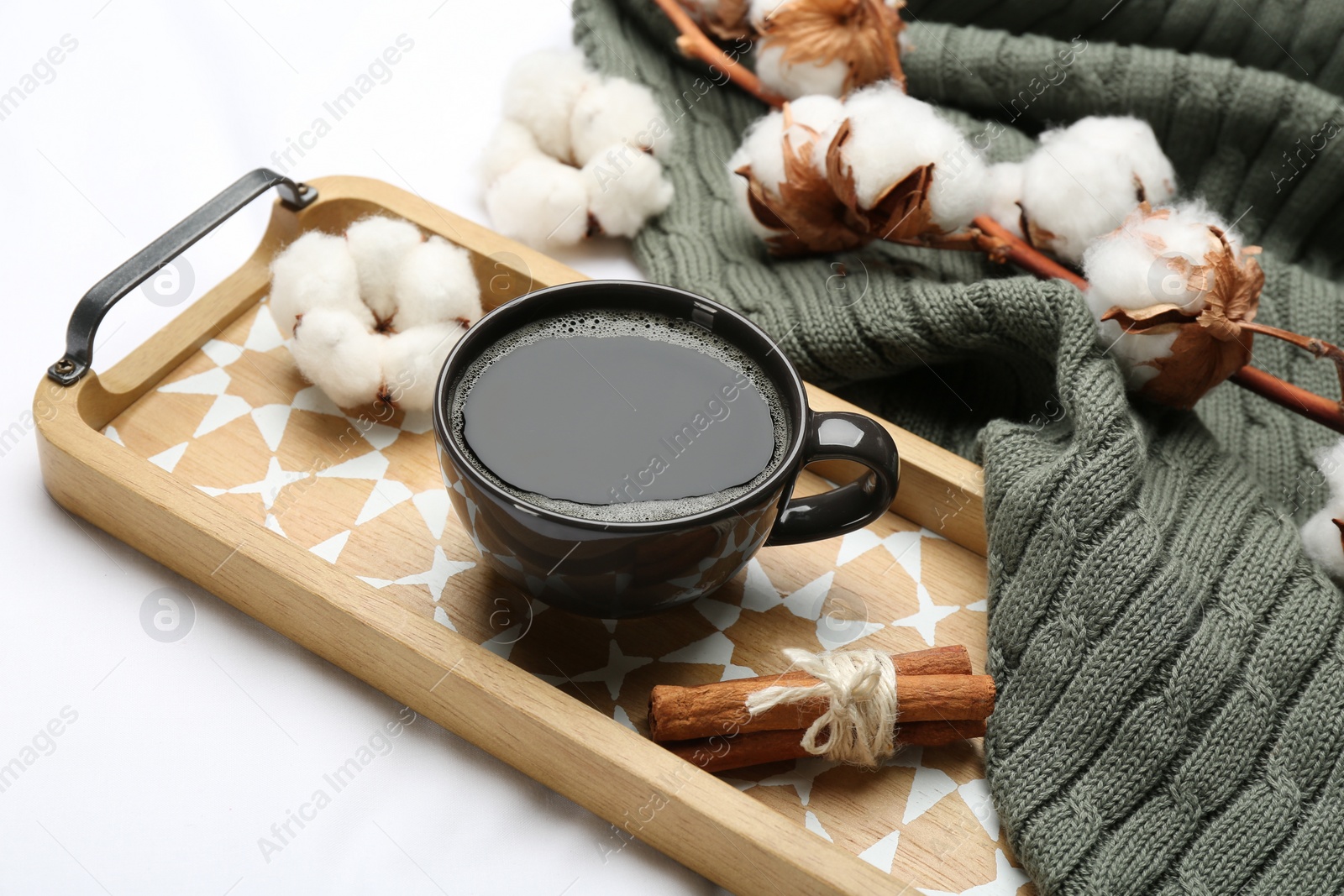 Photo of Composition with hot drink and warm plaid on white bedsheet