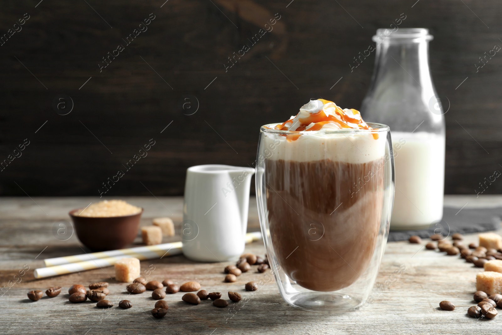 Photo of Glass of coffee with caramel topping on wooden table