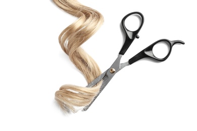 Strand of curly blond hair and thinning scissors on white background, top view. Hairdresser service