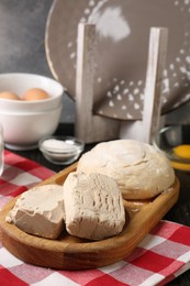 Compressed yeast, salt, eggs and flour on wooden table