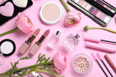 Flat lay composition with different makeup products and beautiful spring flowers on pink background