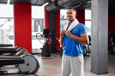 Photo of Happy trainer in modern gym, space for text