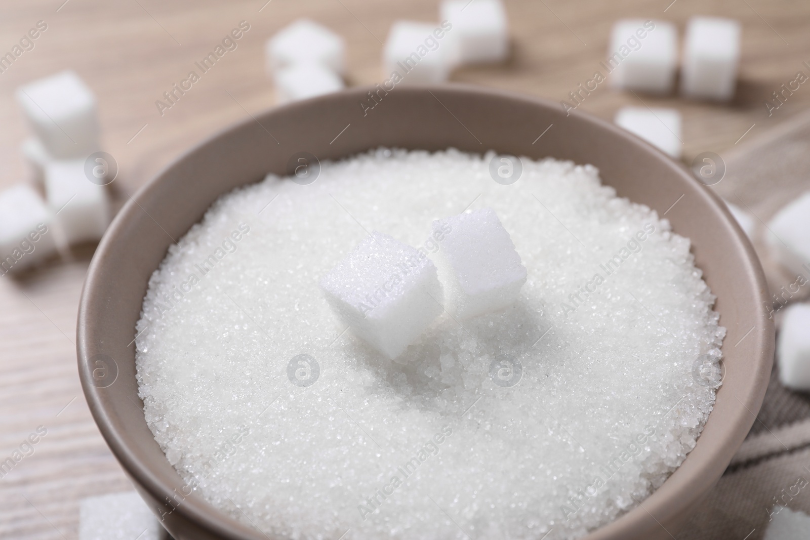 Photo of Different types of white sugar in bowl on table, closeup