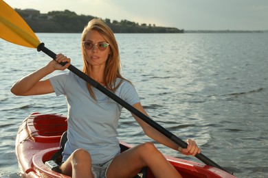 Beautiful woman kayaking on river. Summer activity