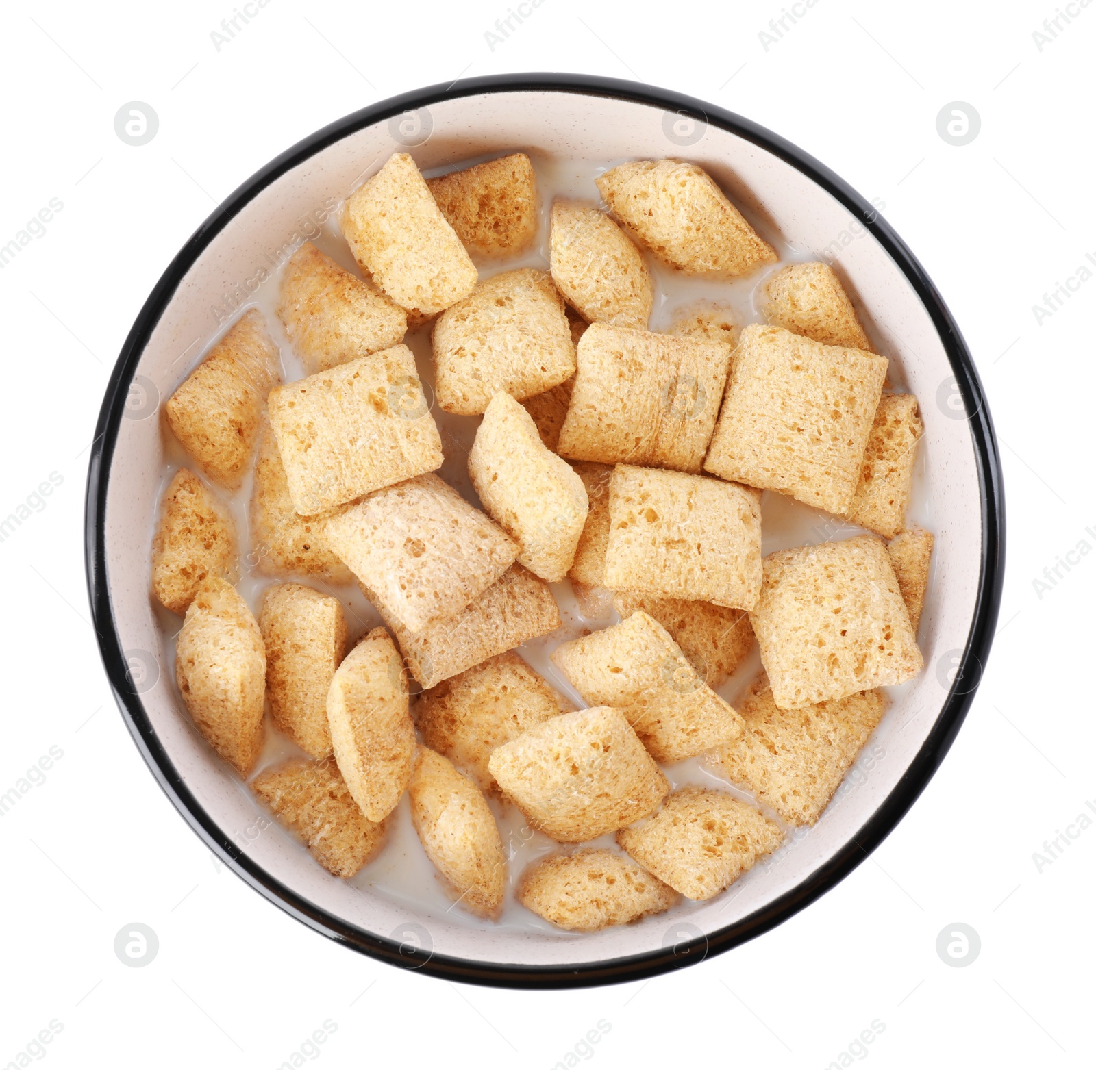 Photo of Tasty corn pads with milk in bowl isolated on white, top view