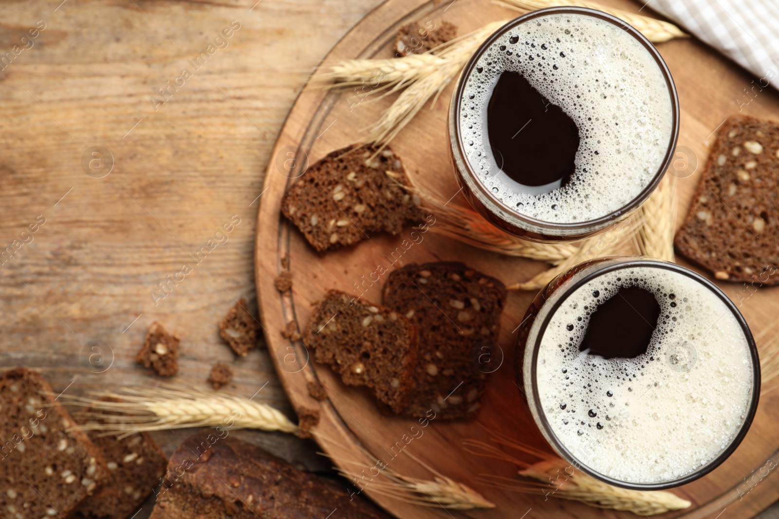 Photo of Delicious kvass, bread and spikes on wooden table, flat lay. Space for text