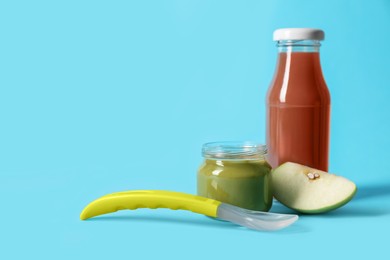 Photo of Healthy baby food, apple and spoon on light blue background. Space for text