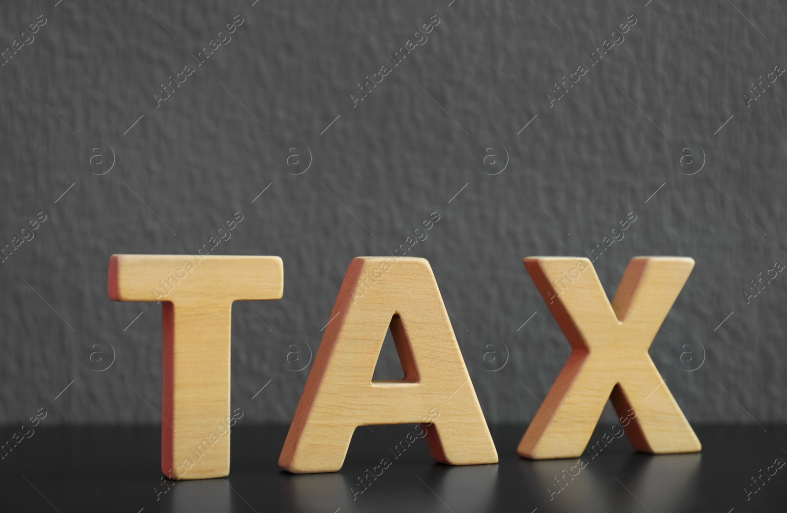 Photo of Word TAX made of letters on table