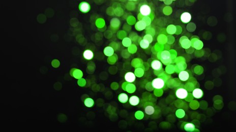 Image of St. Patrick day. Black background with blurred green lights, bokeh effect