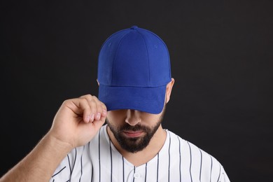 Photo of Man in stylish blue baseball cap on black background