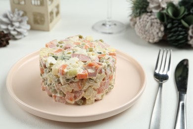 Traditional russian salad Olivier served on white table
