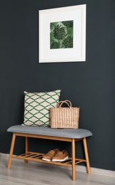 Bench with pillow and bag at black wall. Interior design