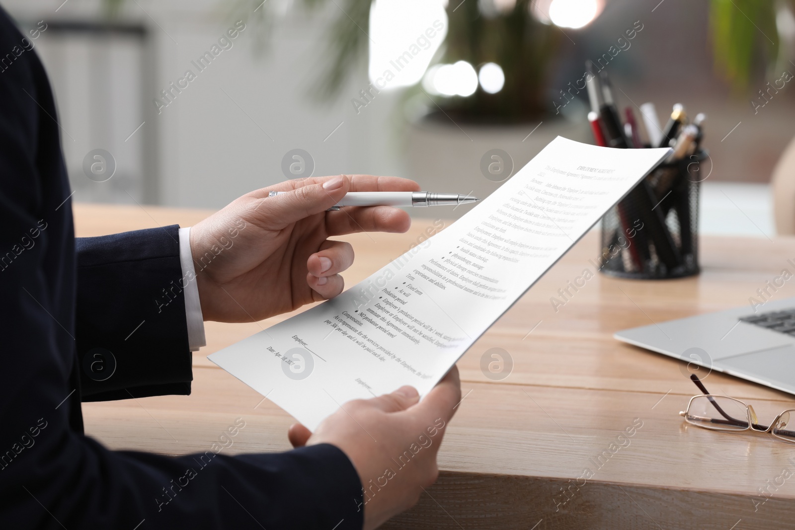 Photo of Man reading document at table in office, closeup. Signing contract