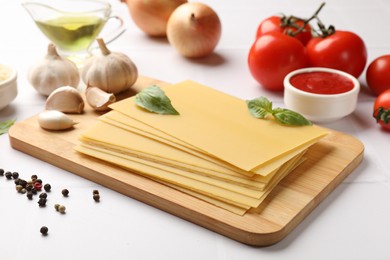 Photo of Ingredients for lasagna on white tiled table