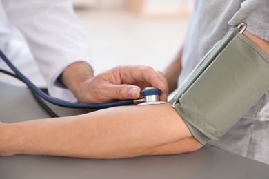 Photo of Doctor measuring patient's blood pressure in hospital