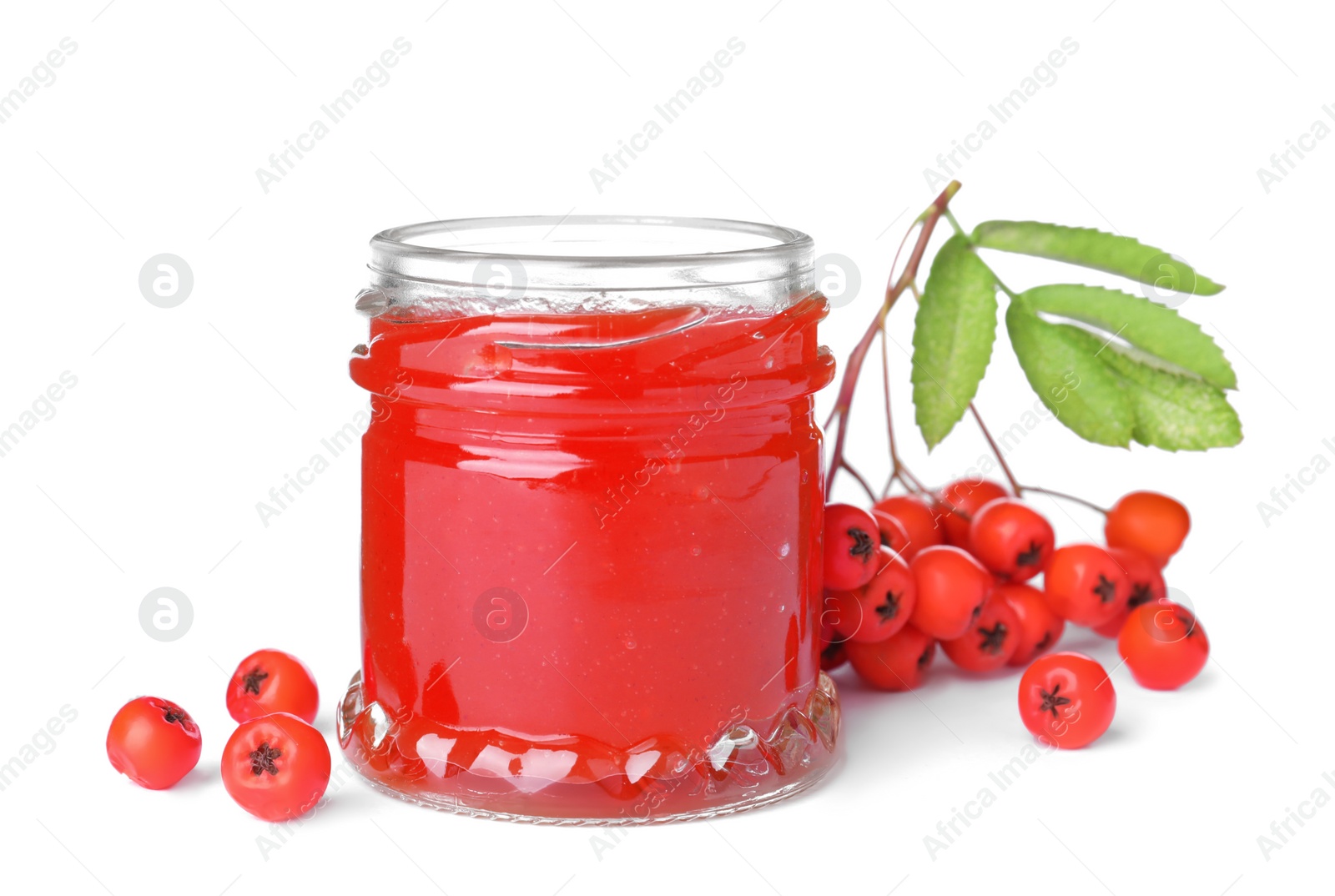 Photo of Delicious rowan jam in glass jar and berries with green leaves on white background