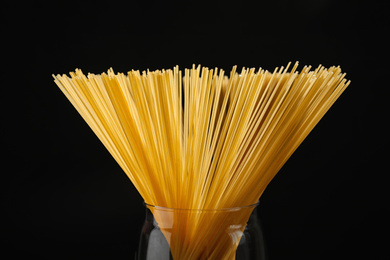 Uncooked spaghetti on black background, closeup. Italian pasta