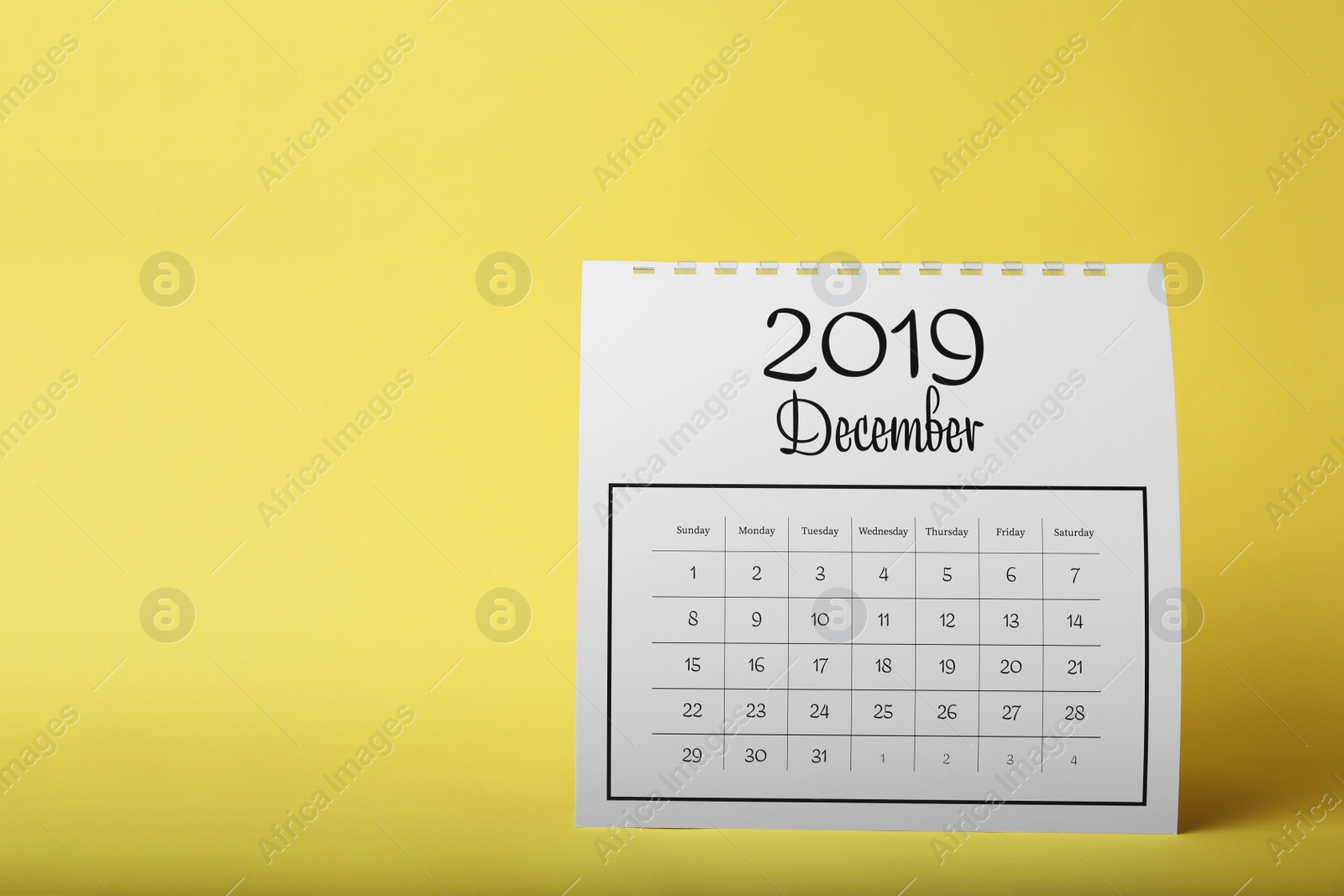 Photo of Paper calendar on yellow background. Planning concept