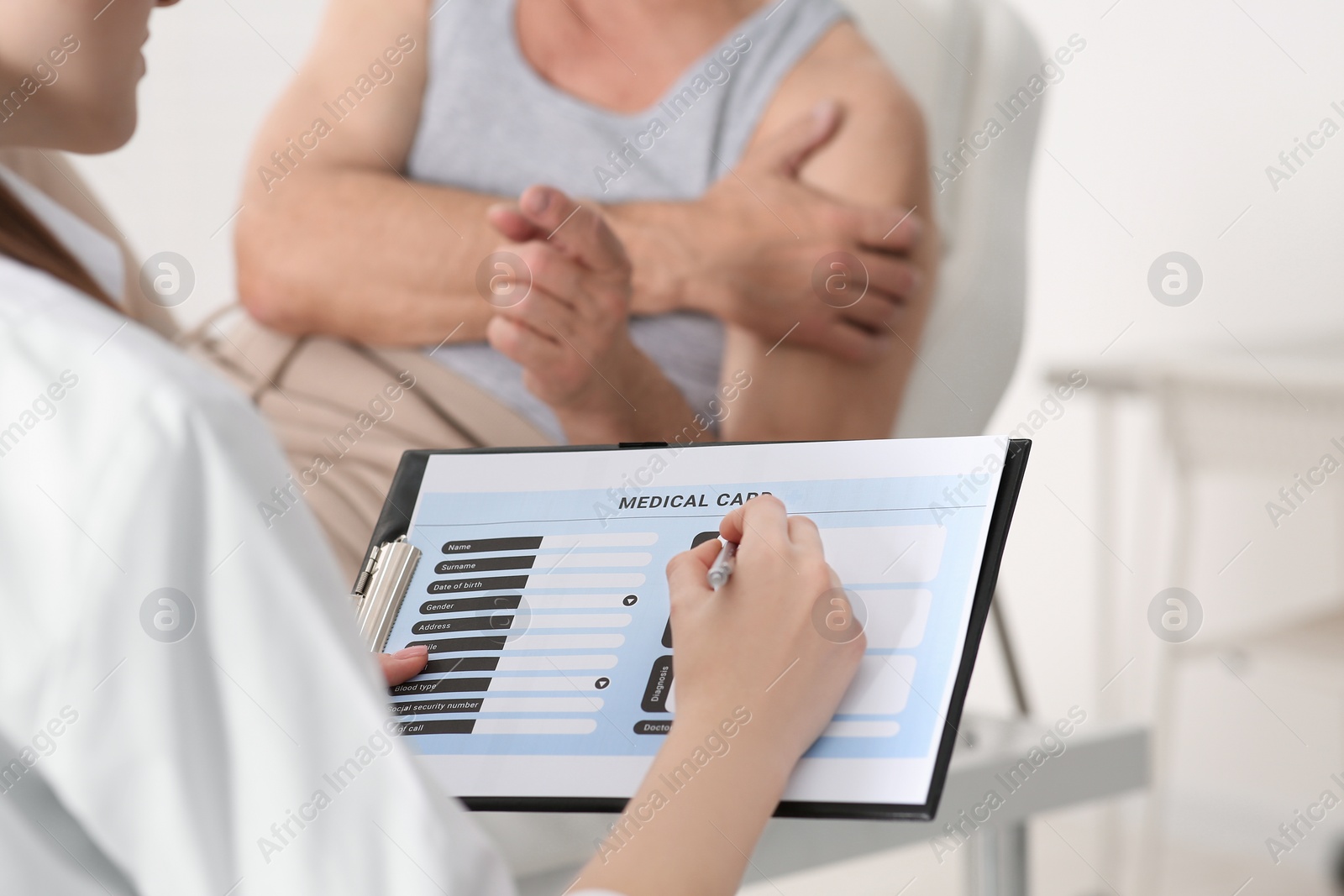 Photo of Doctor filling patient's medical card in clinic, closeup