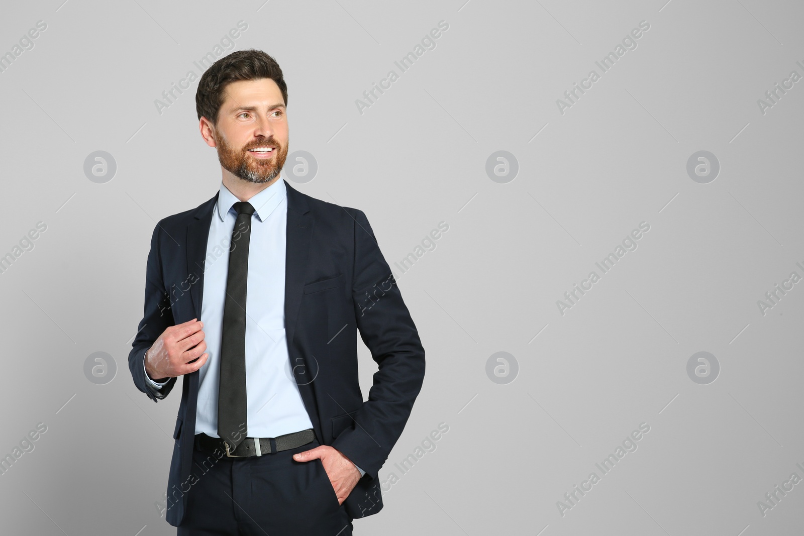 Photo of Handsome real estate agent in nice suit on grey background, space for text