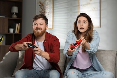 Couple playing video game with controllers at home