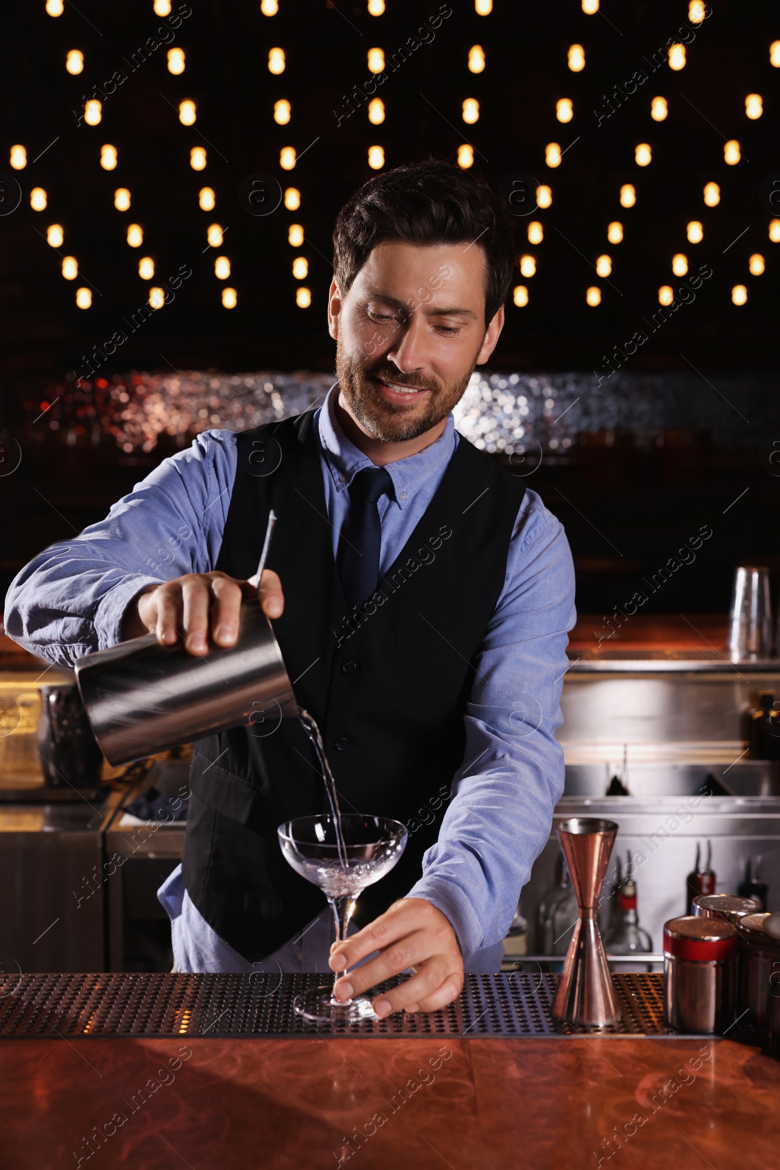 Photo of Bartender preparing fresh alcoholic cocktail in bar