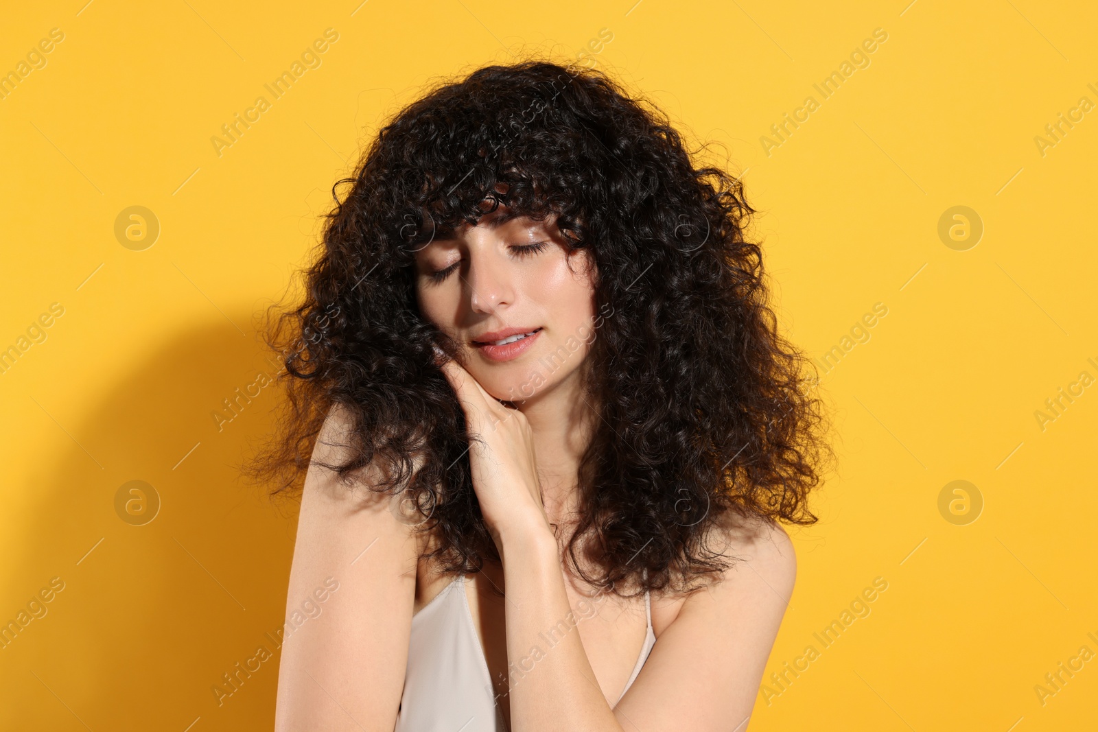 Photo of Beautiful young woman in sunlight on orange background