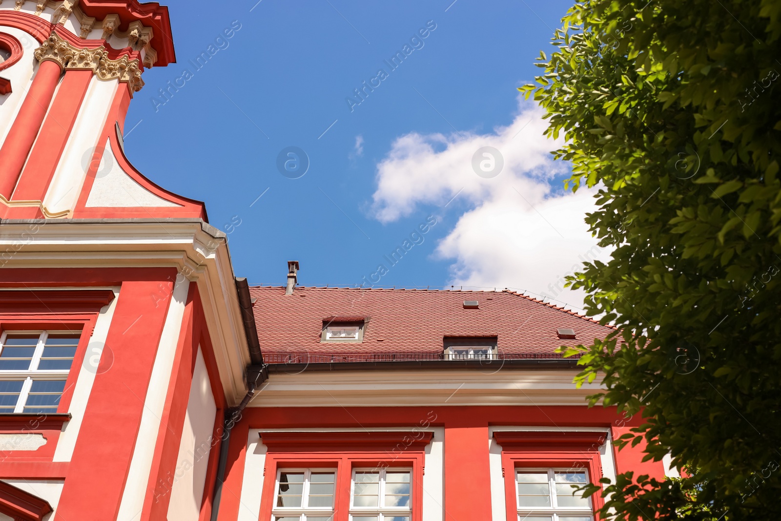 Photo of Beautiful building and green tree against cloudy sky, low angle view