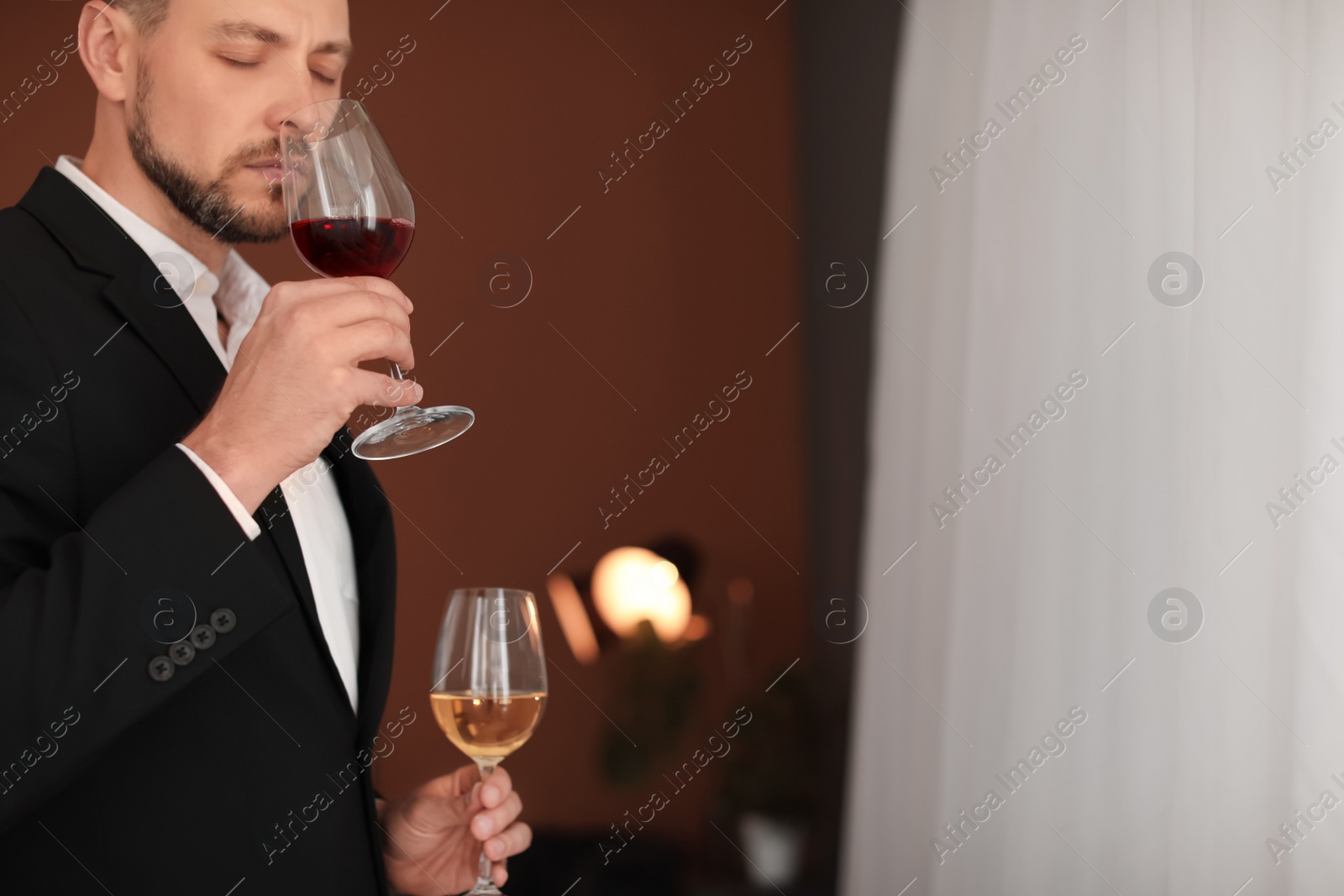 Photo of Young man with glasses of wine indoors