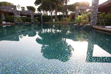 Photo of Outdoor swimming pool with umbrellas and sunbeds at resort